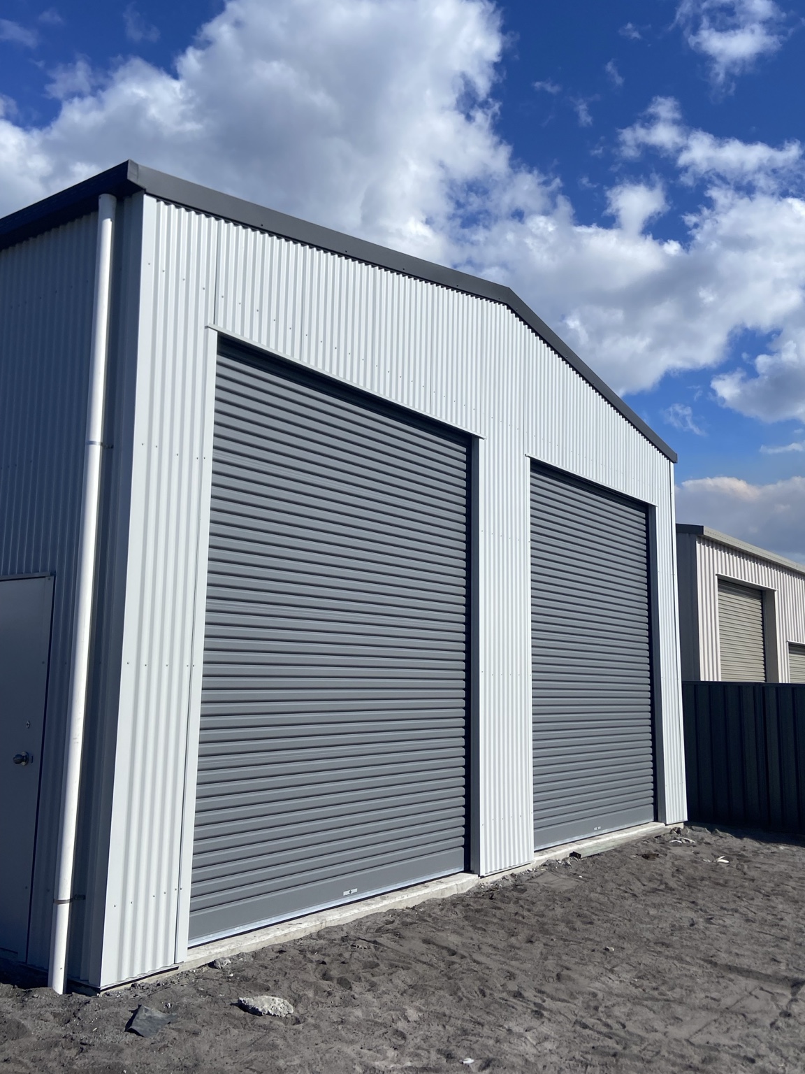 Two large charcoal roller doors installed on a new shed